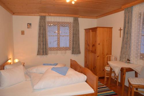 1 dormitorio con 2 camas, mesa y ventana en Haus Kathrein, en Fliess