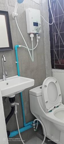 a bathroom with a white toilet and a sink at Kwan Eng Homestay in Phayao