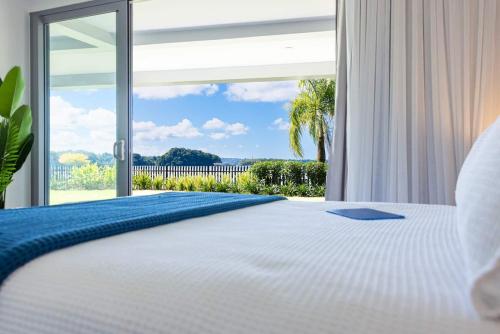 a bedroom with a white bed with a large window at 104 - Suva City Views Oceanfront Backyard in Suva