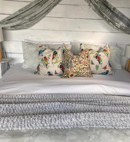 a white bed with four pillows on it at Miranda Sea View Apartment in Miranda