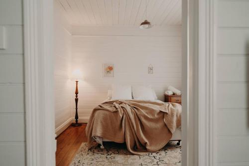 a bedroom with a bed with a blanket on it at Balnagown in Albany