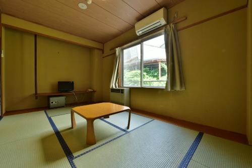 a living room with a table and a window at Hotel Chalet Ryuo in Yamanouchi