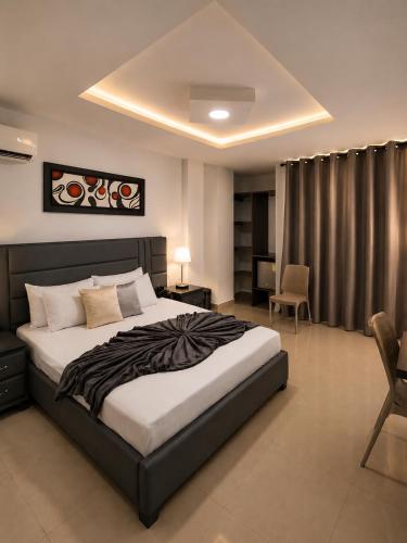 a bedroom with a large bed and a chair at Hotel Don Felipe in Ríohacha