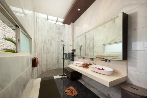 a bathroom with two sinks and a mirror at Pandawa Cliff Ocean view with private beach in Nusa Dua