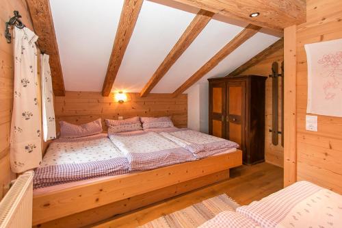 a bedroom with a bed in a wooden house at Müllerkaser in Lofer