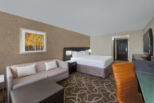 a hotel room with a bed and a couch at Crowne Plaza Kitchener-Waterloo by IHG in Kitchener