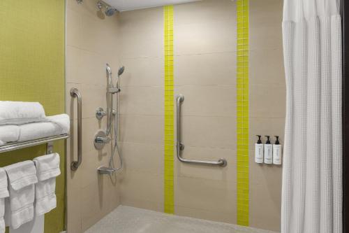 a bathroom with a shower with a yellow stripe on the wall at Crowne Plaza Kitchener-Waterloo by IHG in Kitchener
