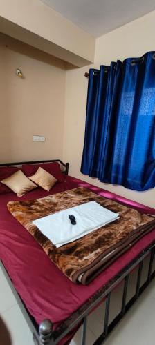 a bedroom with a bed with a blue curtain at Yamuna rooms and dormitory in Ooty