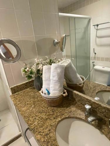 a bathroom with a sink and towels on a counter at Flat Tropical Hotel Vista Espetacular in Manaus