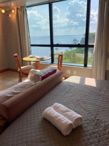 a bedroom with a large bed with two towels on it at Flat Tropical Hotel Vista Espetacular in Manaus