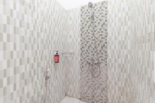 a shower with a shower curtain in a bathroom at RedDoorz Plus @ Tuparev Cirebon 2 in Cirebon