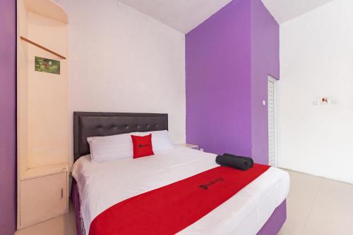 a bedroom with a bed with a red blanket on it at RedDoorz Plus @ Tuparev Cirebon 2 in Cirebon