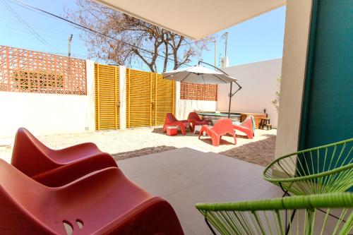 a patio with red chairs and a table and an umbrella at Casa Mila in La Paz