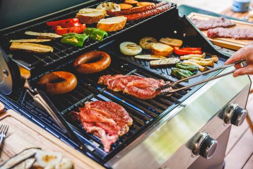 a person is cooking food on a grill at 源泉かけ流し温泉貸切別荘 霧島のテラス in Kirishima
