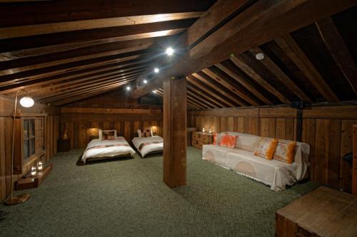 two beds in a room with wooden walls at ISEZI Private Estate in Shibata