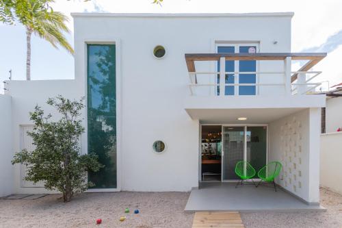 a white house with two green chairs in front of it at Casa Mila in La Paz