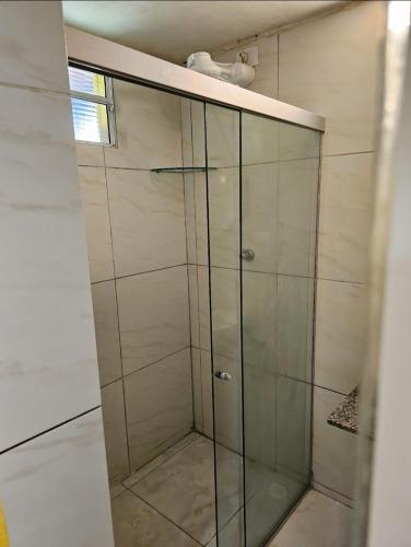 a shower with a glass door in a bathroom at Quarto privativo Pousada Luna in Fernando de Noronha
