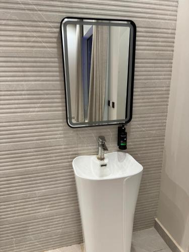 a bathroom with a white sink and a mirror at شاليهات دبليو العمارية W Chalet in Al ‘Ammārīyah