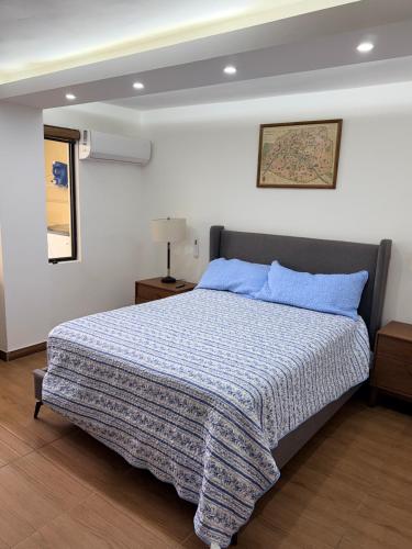 a bedroom with a bed with a blue comforter at Las Minervas in Monterrey