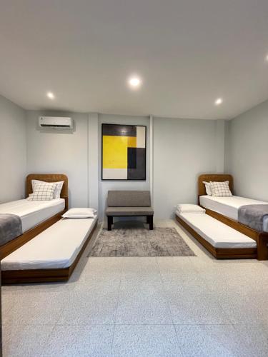 a room with three beds and a table in it at Kuraya Urban Space in Surabaya