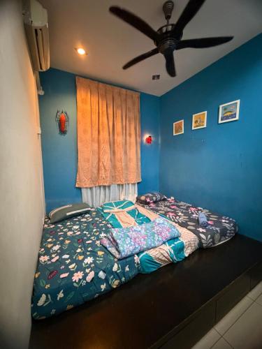 a bed in a bedroom with a ceiling fan at D Aida Homestay Bukit Katil in Kampong Bukit Katil