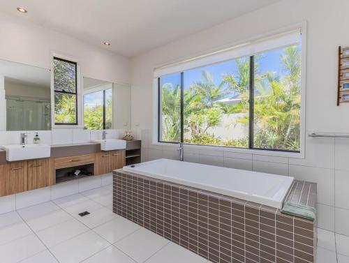 a bathroom with a large tub and two sinks at Longboard Coastal Retreat in Kingscliff