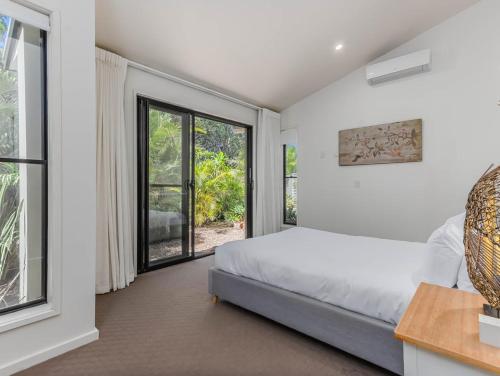 a bedroom with a bed and a large window at Longboard Coastal Retreat in Kingscliff