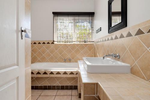 a bathroom with a white sink and a tub at Palm View in Ballito