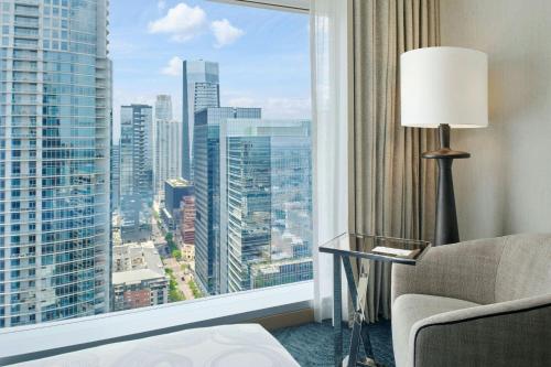 a room with a large window with a couch and a chair and a lamp at JW Marriott Austin in Austin