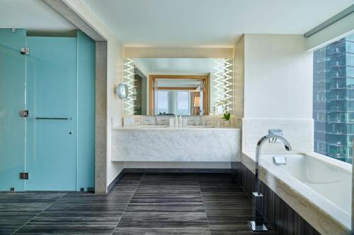 a bathroom with a large tub and a large mirror at JW Marriott Austin in Austin