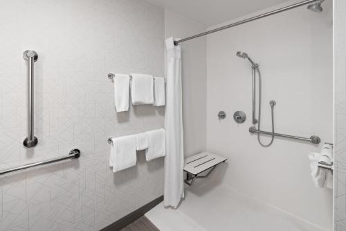 a bathroom with a shower and white towels at Holiday Inn Express Rawlins by IHG in Rawlins
