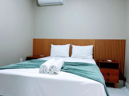 a bedroom with a bed with towels on it at Recanto Sole Luz in Piranhas