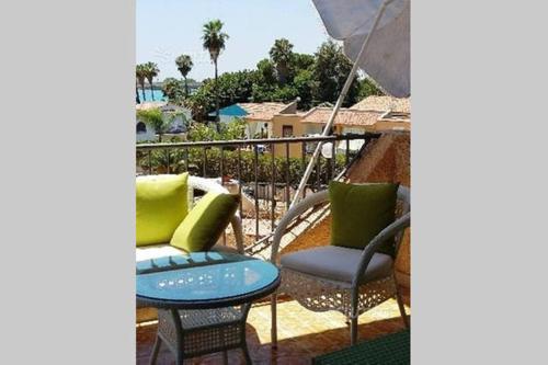 a patio with two chairs and a table and an umbrella at Casa Roby 120 mt Beach in Fontane Bianche