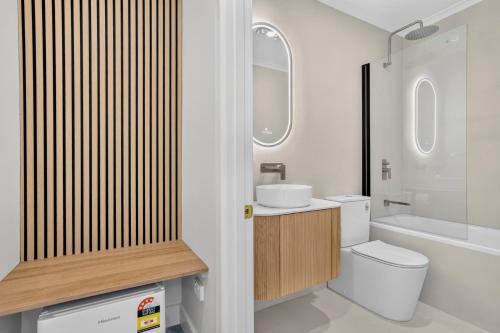 a bathroom with a toilet and a sink at Lufra Beachside Hotel in Eaglehawk Neck