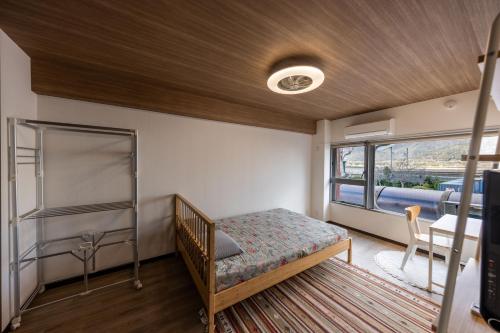 a bedroom with a bunk bed and a balcony at Kame Ame House in Kameoka