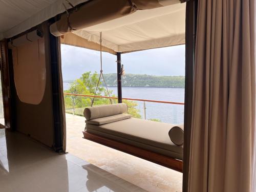 a room with a bed with a view of the water at The Agung & Sunset Tent by BaliSuperHost in Nusa Penida