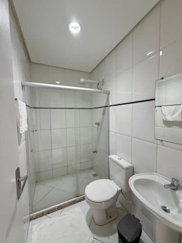 a bathroom with a shower and a toilet and a sink at Prado Hotel in Salgueiro
