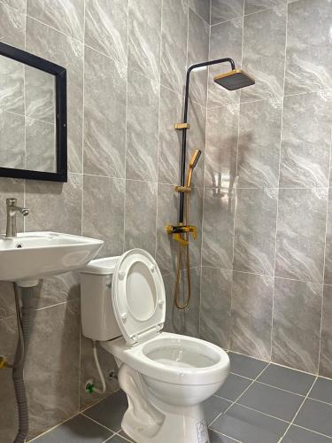a bathroom with a toilet and a sink at Sanctuary Homestay Battambang in Phumĭ Don Téav