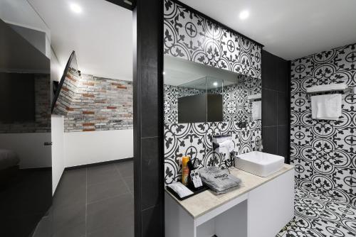 a bathroom with a black and white patterned wall at 서천 마리 호텔 in Seocheon
