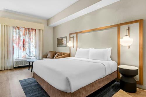 a bedroom with a large white bed and a couch at Fairfield Inn & Suites By Marriott Hinesville Fort Stewart in Hinesville
