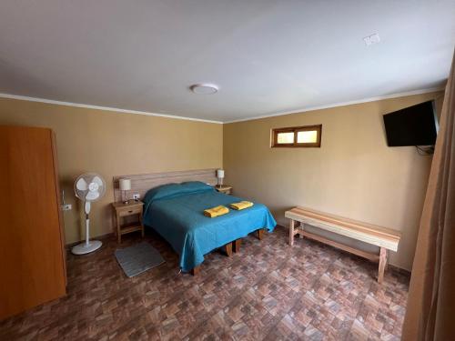 a bedroom with a bed and a table and a fan at Rincon del Inca in San Pedro de Atacama