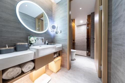 a bathroom with a sink and a mirror at Atour Hotel Wuhan Yellow Crane Tower in Wuhan