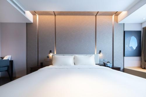 a bedroom with a large bed with white sheets at Atour Hotel Wuhan Yellow Crane Tower in Wuhan