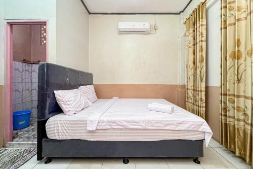a bedroom with a bed in a room at Homestay E Rahayu Anyer RedPartner in Serang