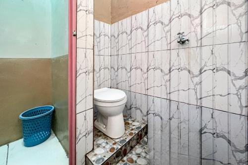 a bathroom with a toilet in a tiled wall at Homestay E Rahayu Anyer RedPartner in Serang