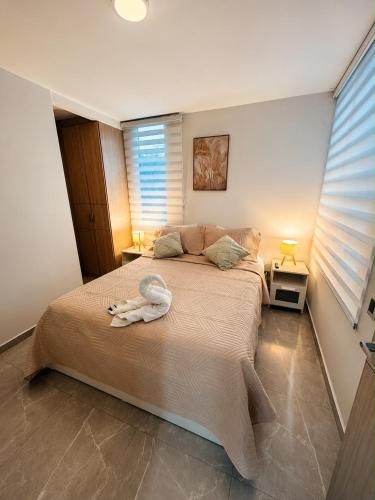 a bedroom with a bed with a towel on it at Apartamento central Moderno de lujo y con piscina in Villavicencio