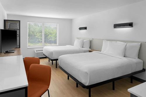 a hotel room with two beds and a television at StudioRes by Marriott LaGrange in La Grange
