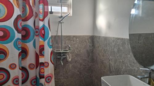 a bathroom with a shower curtain and a sink at Palm Creek Villa in Mont Choisy