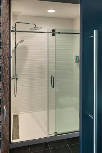 a shower with a glass door in a bathroom at Aloft by Marriott Buffalo Downtown in Buffalo