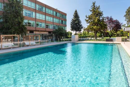 a swimming pool in front of a building at Meliá Madrid Barajas in Madrid